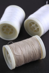 Bobbins with threads on the background of an old wooden table