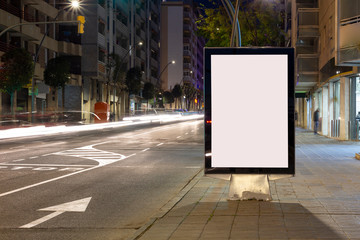 Blank advertisement billboard, with blurred traffic lights at night