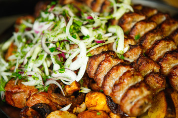Lula kebab with vegetables. Minced mutton chop on the big steel plate