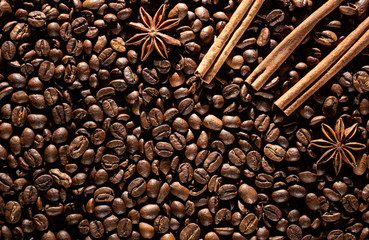 Coffee beans background with different spices: anise stars and cinnamon sticks. Christmas concept.