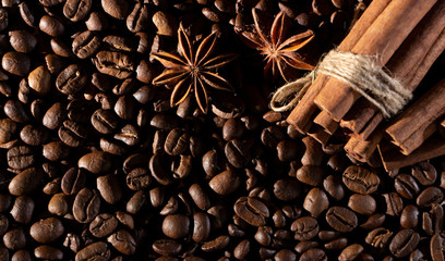 Coffee beans background with different spices: anise stars and cinnamon sticks. Christmas concept.
