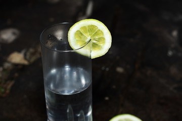 Un vaso de limonada sobre una roca, rodajas de limon
