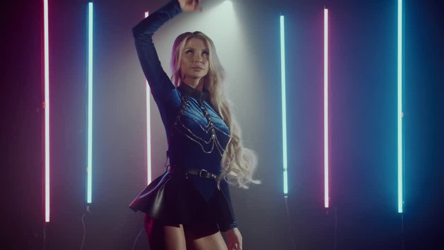 Charming go-go girl is dancing alone in nightclub. She is moving her sexual body and swaying long blonde hair, performing on scene. Shoot with RED RAVEN camera. 