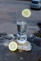 Un vaso de limonada sobre una roca, rodajas de limon