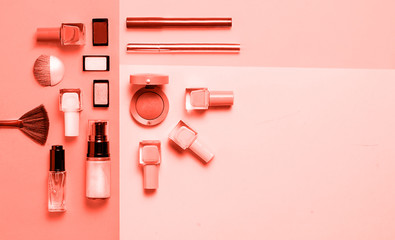 Living Coral colored Decorative cosmetic and nail polishes set on coral background. Minimalism cosmetics style. Top view, flat lay. Creative fashion beauty concept of color of the year 2019. 16-1546