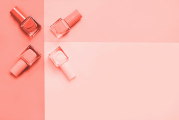 Creative Living Coral colored flat lay of fashion bright nail polishes on a living coral background. Minimal style. Color of the year 2019 concept. blogger concept. 16-1546