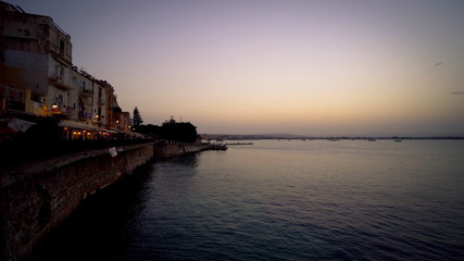 Sunset over the sea to Sicily, the island of Ortigia.