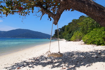 Travel Thailand. Idyllic Exotic Thai beach with turquoise water, palm trees and long tail boats - favourite tourist attraction. Popular tourist holiday/vacation destination. Bright colours. 