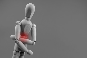 Wooden dummy has pain in stomach black and white photo. Concept of health issues.