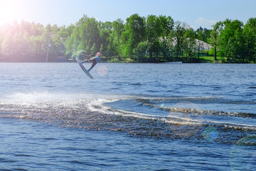 Fototapeta premium Athlete wakeboarder performs a jump with a somersault in the air