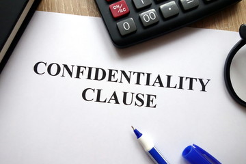 Confidentiality clause document, pen, glasses and   calculator on desk