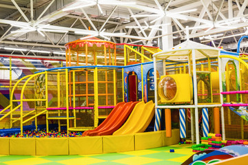 large children's playroom with a slide and colorful balls in entertainment center