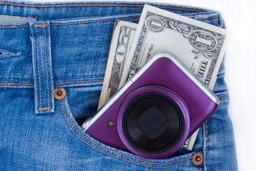 Unknown compact camera and ready money are lying in the side pocket of blue jeans.