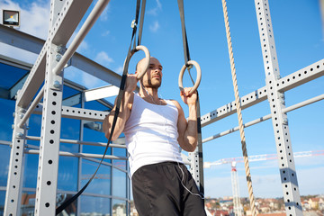 Man doing pull ups training while workout on the street