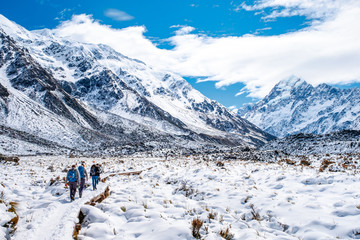 People walking on the boardwalk in Hooker Valley track. Winter snow after a snowy day scene. Mount Cook National Park.