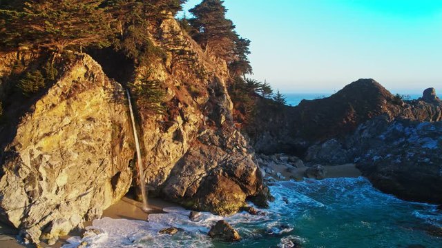 Aerial of McWay Falls in California / Waterfall on the beach 