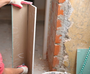 Filling walls and assembly and gluing gypsum boards during renovation of a room.