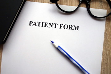 Patient form, pen and glasses on desk