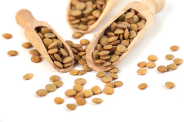 dry lentils on wooden spoon isolated on a white background