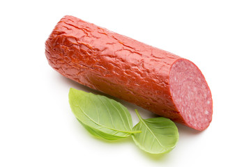 Salami smoked sausage, basil leaves on white background cutout.