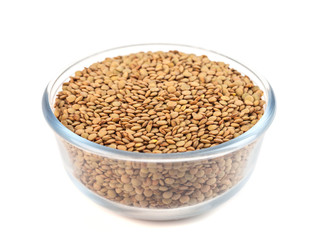 Dry lentil in glass bowl isolated on white background