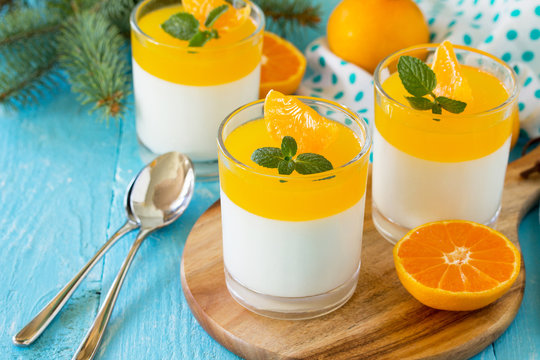 Italian dessert, homemade cuisine. Panna cotta with tangerines jelly and minton a wooden table. Copy space.