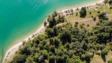 vue en hauteur d'un lac émeraude et ses rives boisées