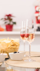 Two glasses of champagne and snacks. 