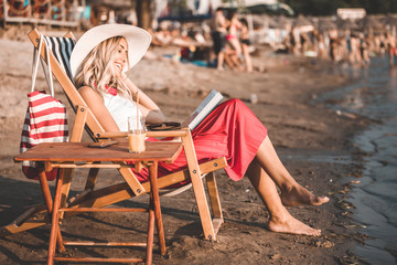 Girl reading a book while sitting on deck chair
