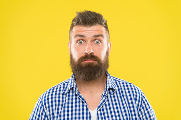Surprising news. Man bearded hipster wondering face yellow background close up. Guy surprised face...