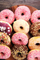 assorted donuts with chocolate frosted, pink glazed and sprinkles donuts