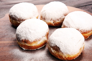 German donuts with jam and icing sugar. Carnival powdered sugar raised donuts