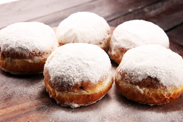 German donuts with jam and icing sugar. Carnival powdered sugar raised donuts