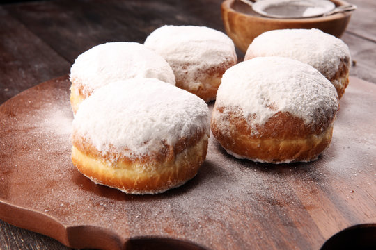 German donuts with jam and icing sugar. Carnival powdered sugar raised donuts