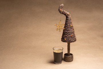 Do-it-yourself coffee tree made from coffee beans with bead ornaments and a glass of coffee