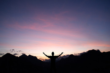 silhouette of a man on top of mountain at sunset