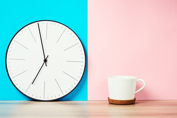 vintage wall clock and cup of coffee on a pink and blue pastel background