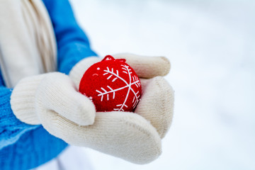 girl holds in her hands an decoration for a New Year tree in the shape of a heart. Girl decorates the Christmas tree. New Year's and Christmas © Andrey Cherkasov