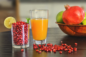 Glass of freshly squeezed orange juice and pomegranate seeds