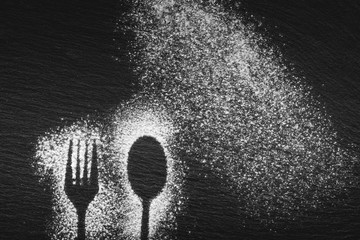 Silhouette of a fork and a spoon drawn with white flour