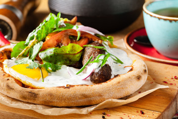 English breakfast fried egg, ham,sausage, bacon,salad and toast on wood background
