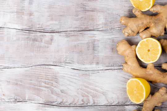 Background. Healthy food. Ingredients for detox lemonade, lemon and ginger on white wooden background, top view, copy space.