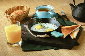 fried eggs fried in a frying pan for breakfast with bread