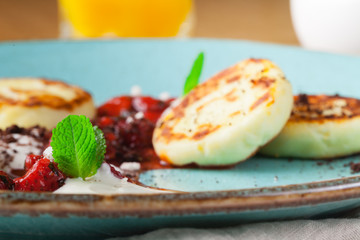 Fresh breakfast with cottage cheese pancakes with sour cream and raspberry jam