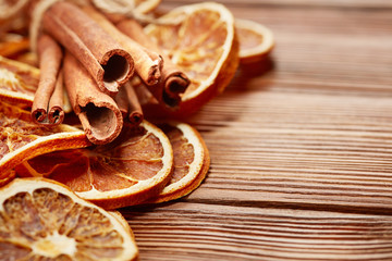 dry oranges, cinnamon sticks and anise on wooden background