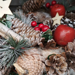 Christmas colorful decoration closeup image. tree pine cones, apples, star and cinnamon sticks in spruce branches