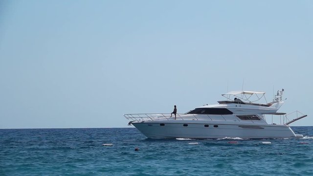 Yacht with people sailing on the waves. Slow motion