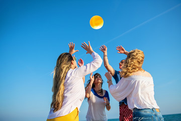 Group of young people playing volleyball on the beach