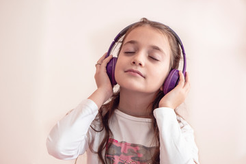 A Happy little girl listening music lying on the sofa living-room