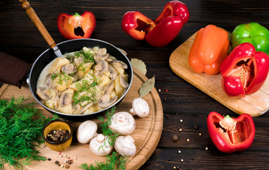 Potatoes with mushrooms in a skillet on a wooden background